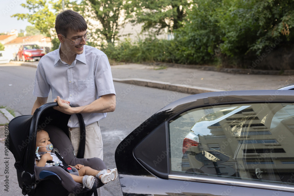 father putting baby in car seat, everyday lifestyle father putting baby in car seat, everyday lifestyle