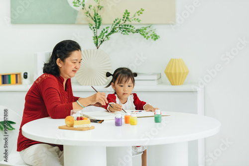 Happe mature lady helping her grandchild creating pictures photo