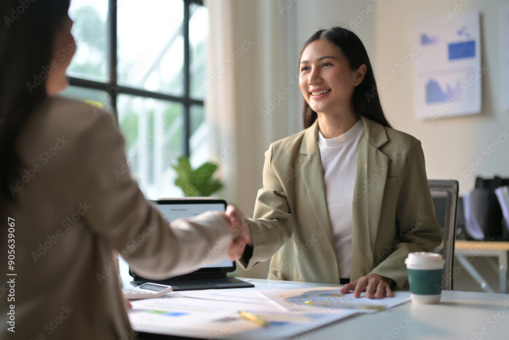 Business Meeting in Modern Office with Two Professional Women Shaking Hands and Discussing Documents Business Meeting in Modern Office with Two Professional Women Shaking Hands and Discussing Documents