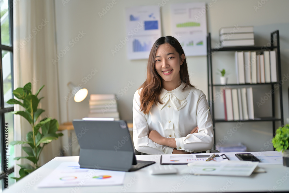 Confident Businesswoman Working at Desk with Digital Tablet in Modern Office Setting Confident Businesswoman Working at Desk with Digital Tablet in Modern Office Setting