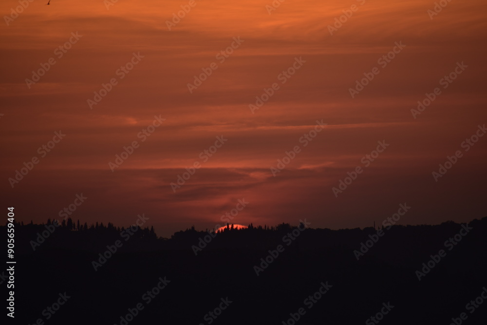 Epic sunset landscape sky with big bright sun going behind the mountains in Greece Epic sunset landscape sky with big bright sun going behind the mountains in Greece