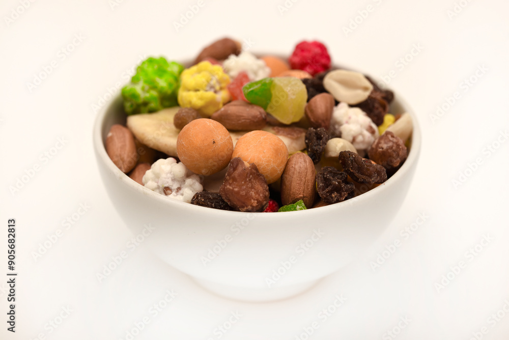 Sweet assorted nuts and dried fruits in a plate on a white background. Sweet assorted nuts and dried fruits in a plate on a white background.