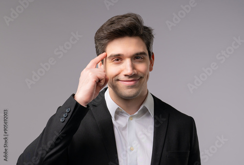 Clever businessman with gesture - you, think about it. Looking camera on grey