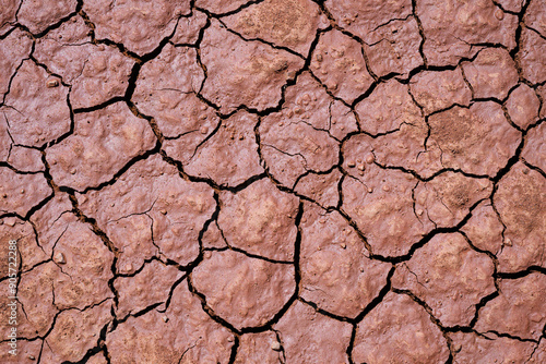 Natural desert wet sand mosaic pattern in cracked chocolate colored ground forming background photo