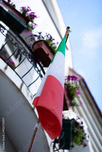 Italy flag on a building with flowers
