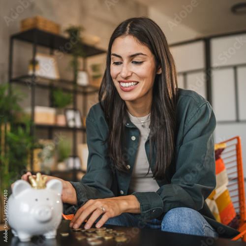 happy adult caucasian woman save money coins in the piggy bank photo