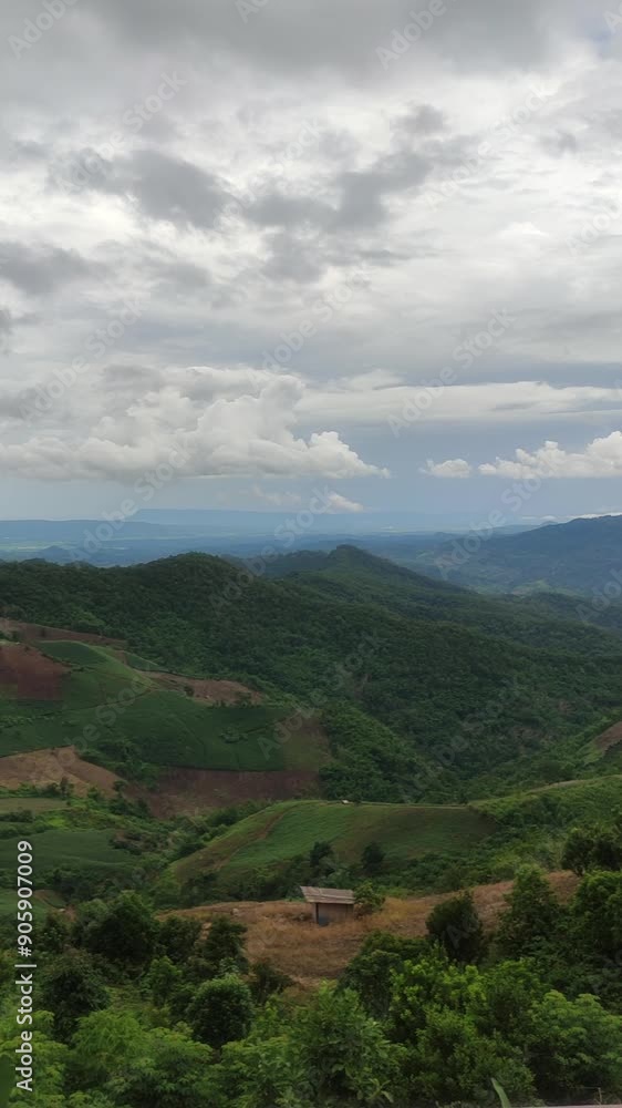 A breathtaking view of lush green hills and valleys under a dramatic cloudy sky, showcasing the serene beauty of the countryside. A breathtaking view of lush green hills and valleys under a dramatic cloudy sky, showcasing the serene beauty of the countryside.