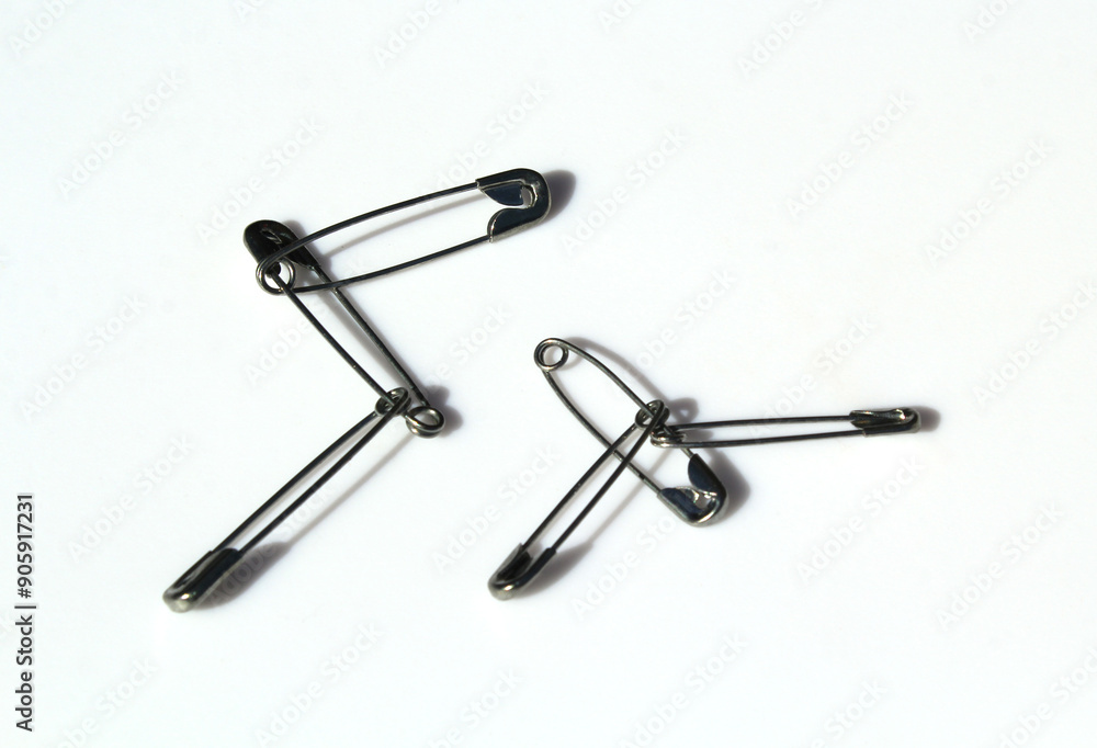 Interlocking safety pins on a white background Interlocking safety pins on a white background