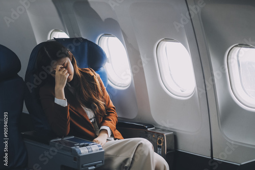 Tableau sur toile Photo of a frustrated woman sitting on an airplane with her head in her hands