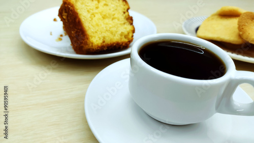 Close up of cup of coffee in a traditional brazilian breakfast containing piece of cornmeal cake and butter cookies
 photo