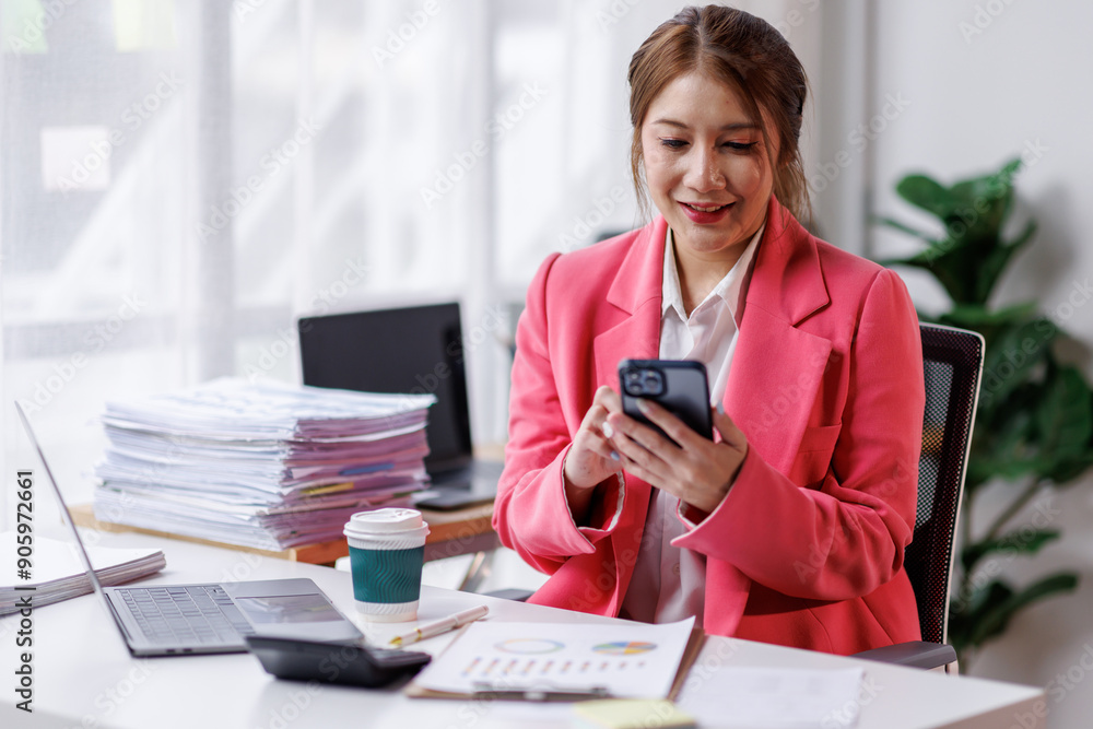 Business asian woman sitting in an office and using a phone, smartphone. Business asian woman sitting in an office and using a phone, smartphone.