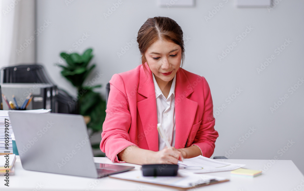 Asian business woman using calculator and laptop for do math finance on wooden desk in office and business working background, tax, accounting, statistics and analytic research concept Asian business woman using calculator and laptop for do math finance on wooden desk in office and business working background, tax, accounting, statistics and analytic research concept