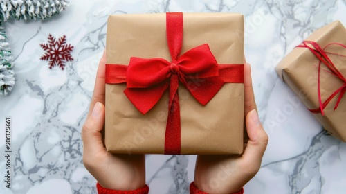 Hands holding a beautifully wrapped Christmas gift with a bow