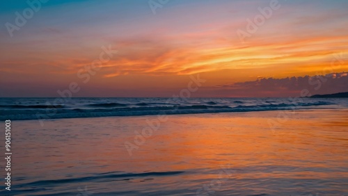 A vibrant sunset over the ocean with rolling waves and billowing clouds