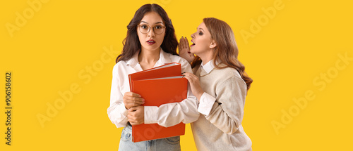 Business colleagues gossiping on yellow background photo