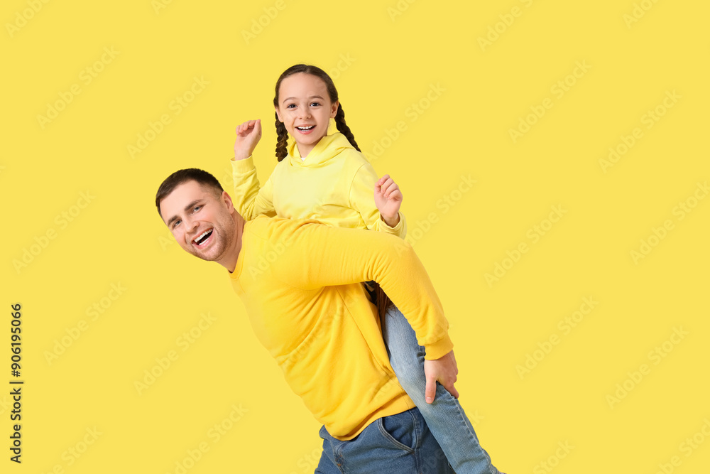 Father playing with his daughter on yellow background Father playing with his daughter on yellow background