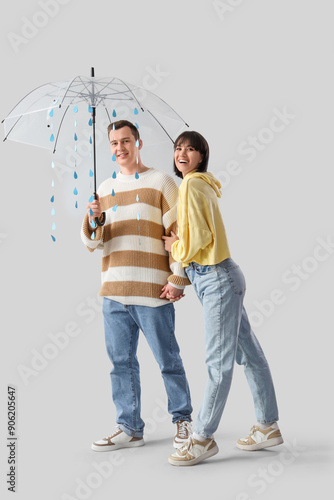 Young couple holding umbrel...