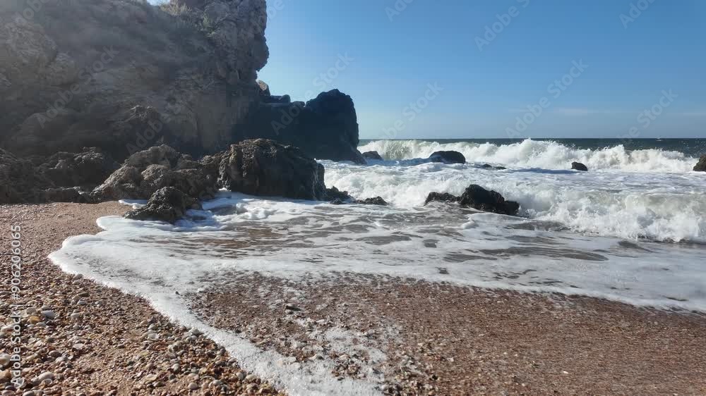 Waves crash against the rocky shoreline of Crimea, showcasing the natural beauty of the region along the Sea of Azov. Waves crash against the rocky shoreline of Crimea, showcasing the natural beauty of the region along the Sea of Azov.