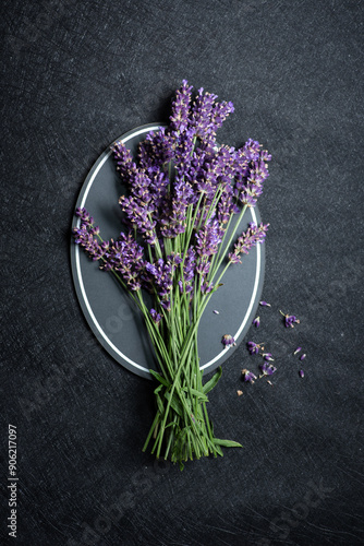 Obraz na płótnie Bunch of fresh lavender flowers arranged on a plate over dark textured background. w salonie