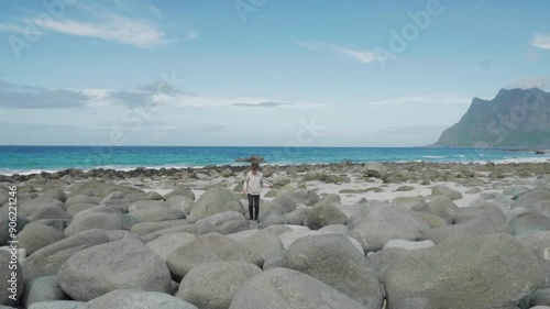 Boy playing at the beach with blue sea and beautiful mountains in the background photo