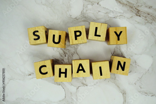 Suply Chain with wooden blocks alphabet letters on marble background photo