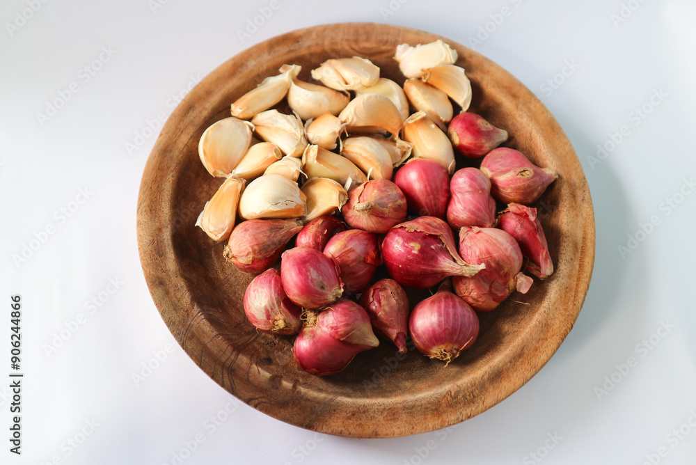 Obraz premium Traditional herbs and spices, placed on wooden plates such as shallots and garlic 