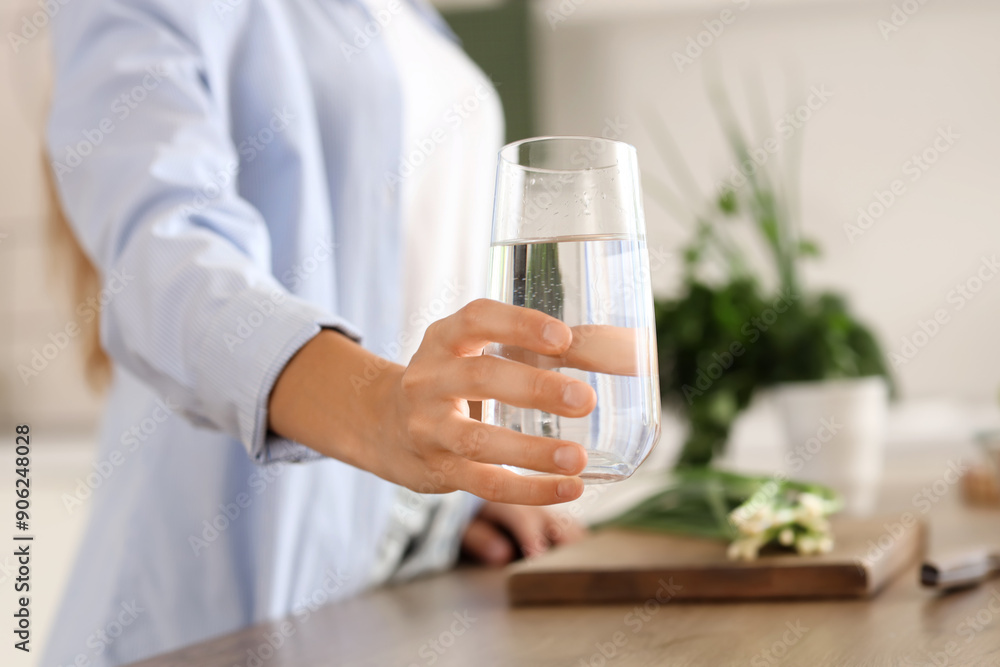Young woman with glass of water in kitchen, closeup Young woman with glass of water in kitchen, closeup