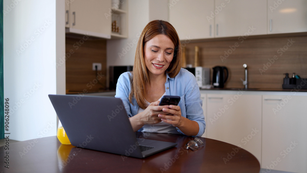 Woman tecting on smartphone while working from home Woman tecting on smartphone while working from home