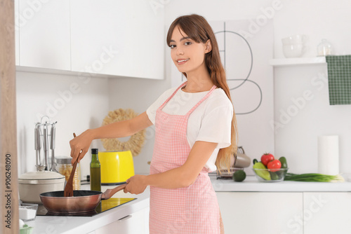 Young housewife frying vege...
