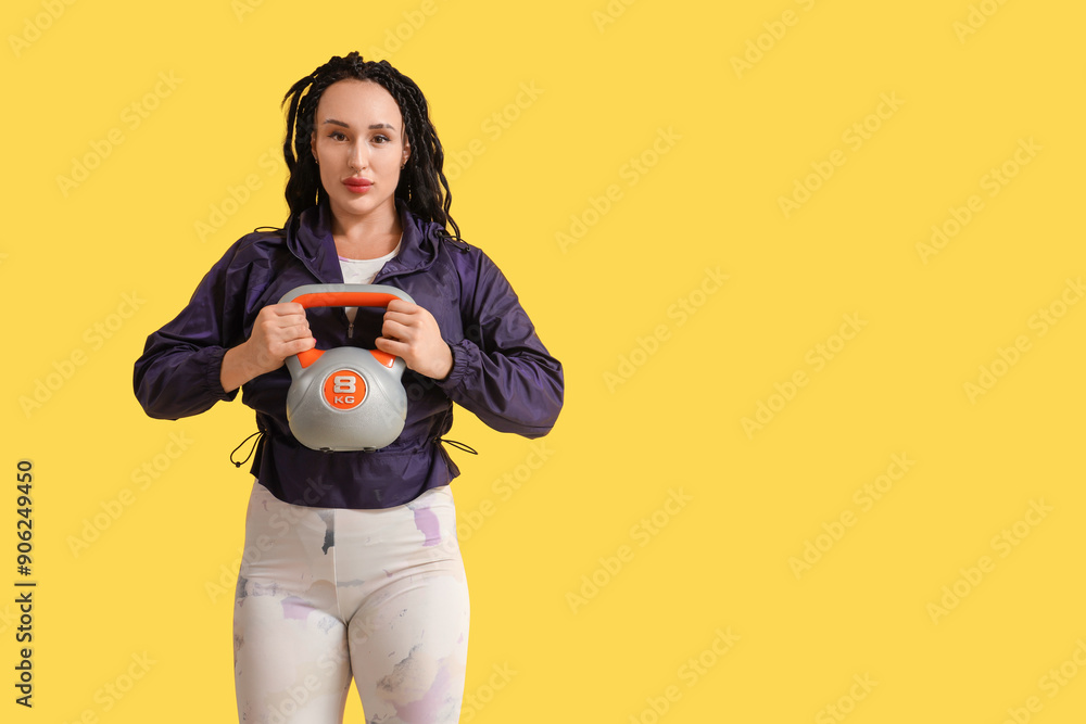 Female bodybuilder with kettlebell on yellow background Female bodybuilder with kettlebell on yellow background
