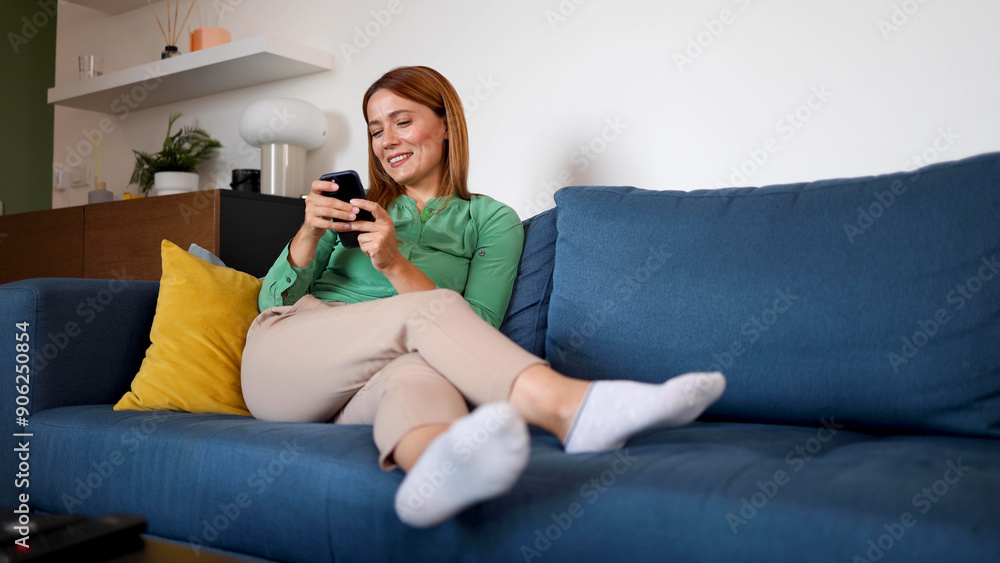 Woman relaxing on the couch and using smartphone Woman relaxing on the couch and using smartphone