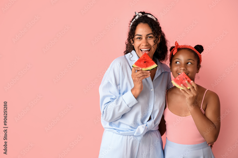 Beautiful young African-American woman and her cute daughter with pieces of fresh watermelon on pink background Beautiful young African-American woman and her cute daughter with pieces of fresh watermelon on pink background