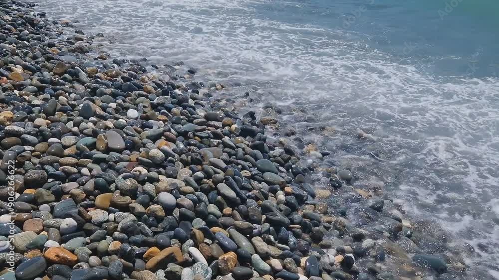 Waves break on the rocks on the beach, sea spray, sunlight is reflected in the water. Waves break on the rocks on the beach, sea spray, sunlight is reflected in the water.