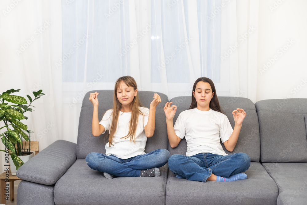 People, relationships, family, relaxation, yoga and meditation concept. girls sitting on bed, looking up, making mudra gesture, praying or meditating People, relationships, family, relaxation, yoga and meditation concept. girls sitting on bed, looking up, making mudra gesture, praying or meditating