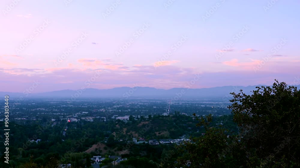 Overlooking the stunning cityscape from Mulholland Drive in Los Angeles, California, the sunset casts a warm glow over the urban skyline and surrounding mountains. Overlooking the stunning cityscape from Mulholland Drive in Los Angeles, California, the sunset casts a warm glow over the urban skyline and surrounding mountains.