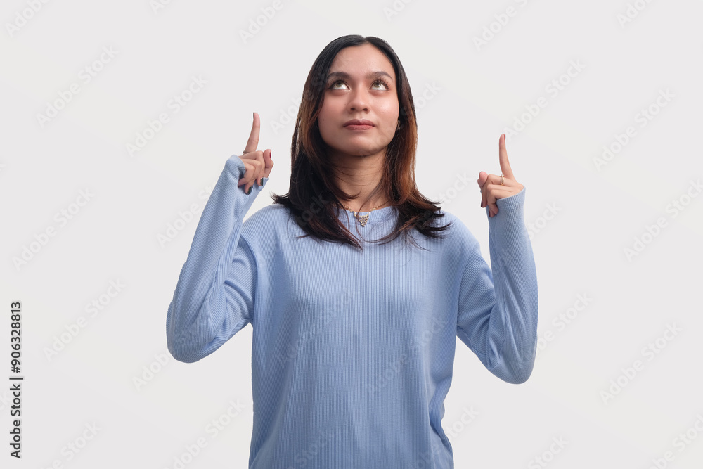 Excited Asian woman pointing something above Excited Asian woman pointing something above