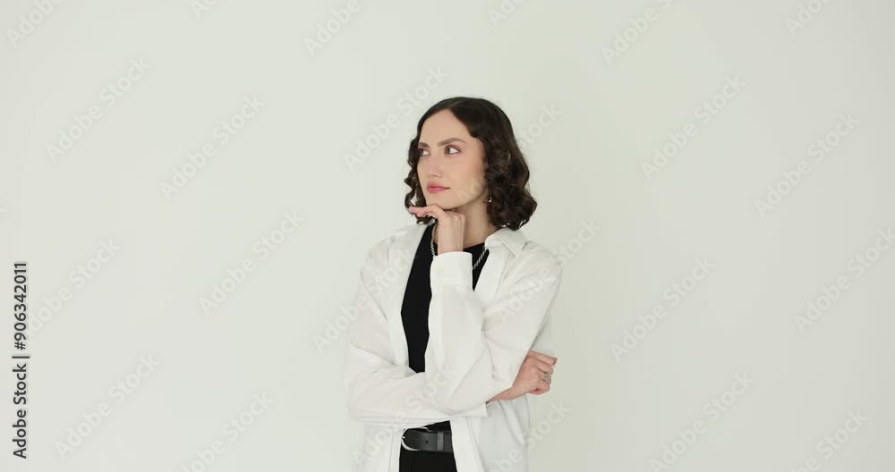 Young woman raises index finger demonstrating idea gesture on white background. Inspired female with curly hair finds solution to problem Young woman raises index finger demonstrating idea gesture on white background. Inspired female with curly hair finds solution to problem