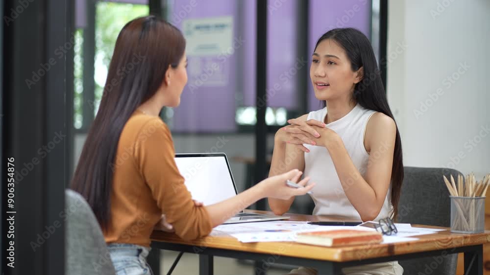 Business meeting - two asian women talking in the office. Business meeting - two asian women talking in the office.