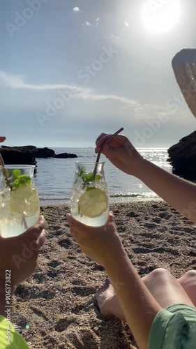 two girlfriends drinking cocktails on the beach
