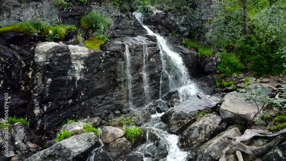 Wild mountain stream flows through the stones from the waterfall. Wild mountain stream flows through the stones from the waterfall.