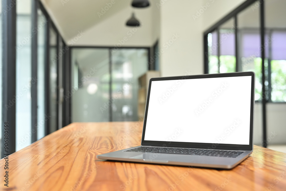 Fototapeta premium A laptop computer with white blank screen on wooden on conference table in modern office