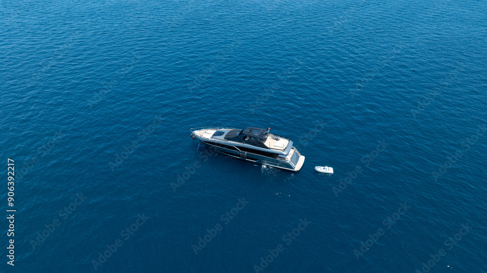 A breathtaking aerial view of a luxurious yacht cruising on the blue waters A breathtaking aerial view of a luxurious yacht cruising on the blue waters