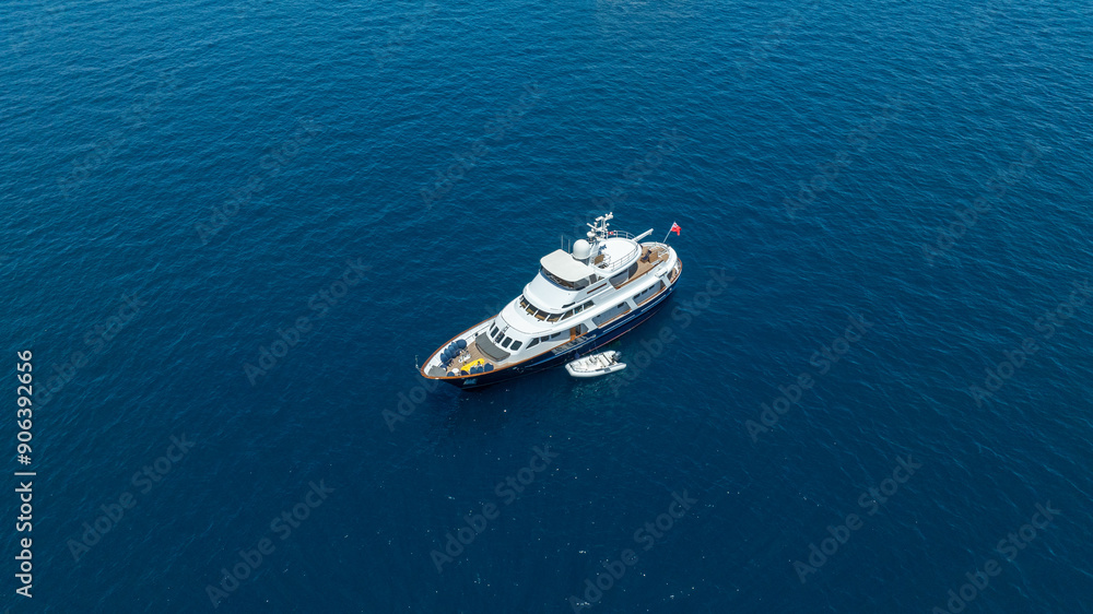 A breathtaking aerial view of a luxurious yacht cruising on the blue waters