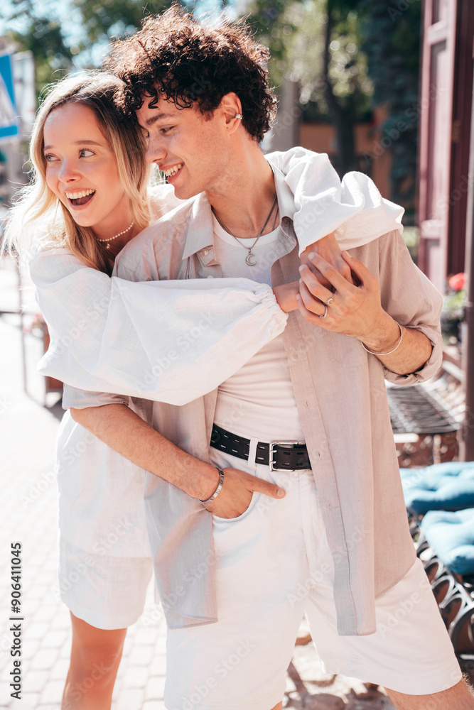 Fototapeta premium Smiling beautiful woman and her handsome boyfriend. Woman in casual summer clothes. Happy cheerful family. Female having fun. Couple posing in the street it sunny day. Cheerful and happy