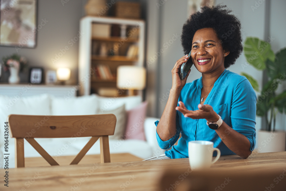 Smiling african american woman talking on the phone. Mature black woman in conversation using mobile phone while laughing. Young cheerful lady having fun during a funny conversation call. Smiling african american woman talking on the phone. Mature black woman in conversation using mobile phone while laughing. Young cheerful lady having fun during a funny conversation call.