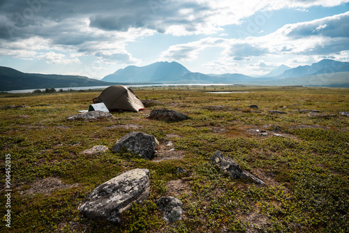 Padjelanta National Park in swedish lapland. On a hiking outdoor adventure. A hikers tent and beautiful landscape view from Nordkalottleden Kutjaurestugan towards Gisuris Mountain. photo