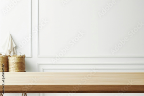 Empty wooden table top in front of blurred white wall background with wicker baskets