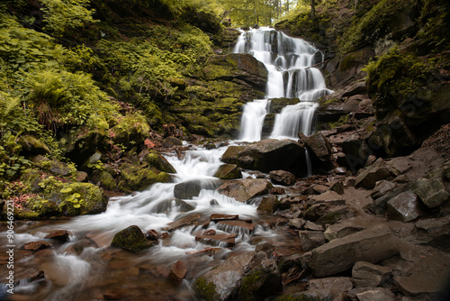 Tourist place in Ukraine - Shipot waterfall, located in a mountainous landscape surrounded by dense forest. Water cascades down from the rocks, forming picturesque tiers.