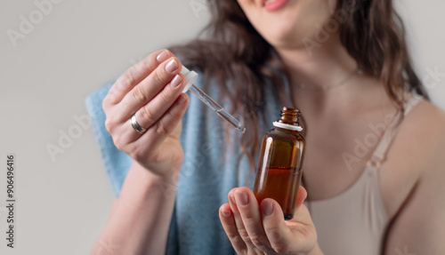 Tableau sur toile Girl applying serum on her hand, showcasing anti-aging effects with antioxidants and active ingredients like Vitamin C and retinol for firmer skin