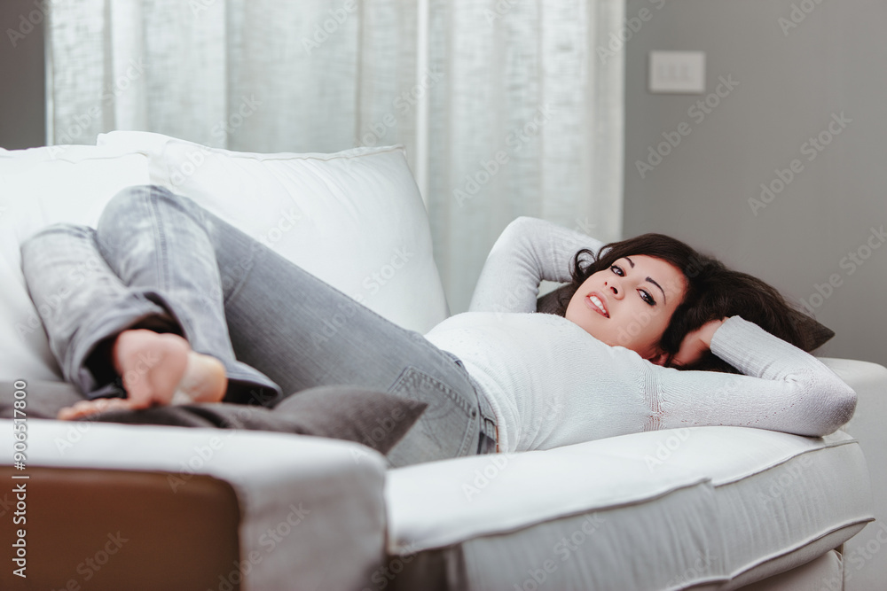 Young woman relaxing on couch at home Young woman relaxing on couch at home